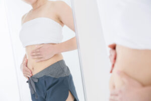woman looking at stomach mirror