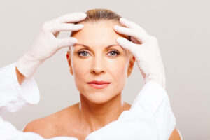 Doctor,Doing,Skin,Check,On,Middle,Aged,Woman,Before,Cosmetic